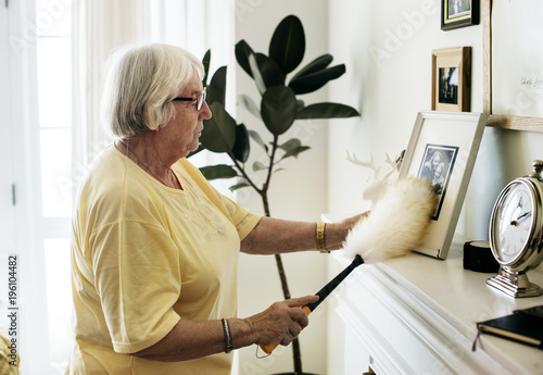Senior woman dusting a family photo photo