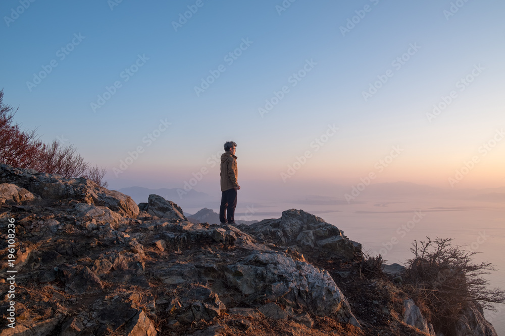 A Man looking the sea stands on the cliff