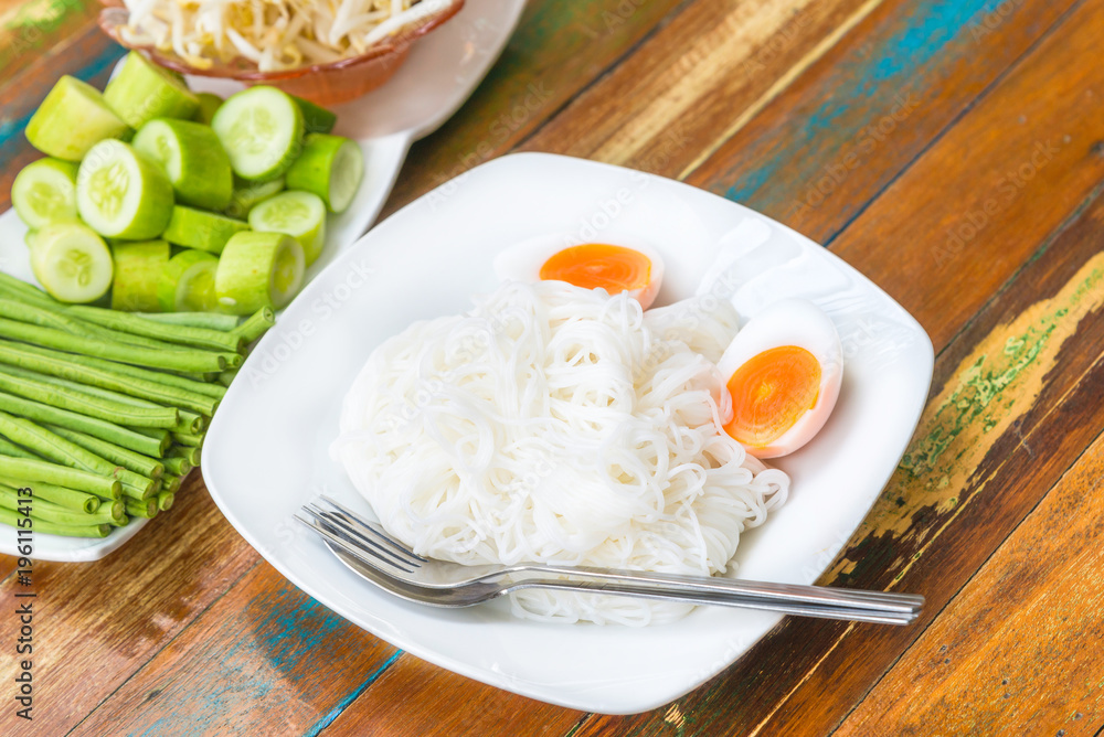Rice vermicelli and vegetables with Long bean and hoary basil on wooden table the traditional delicious Thai food..