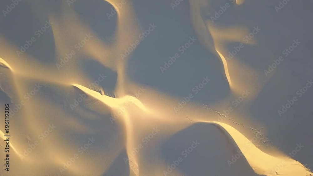 Flying sideways above the sand dune with shadow and light pattern.