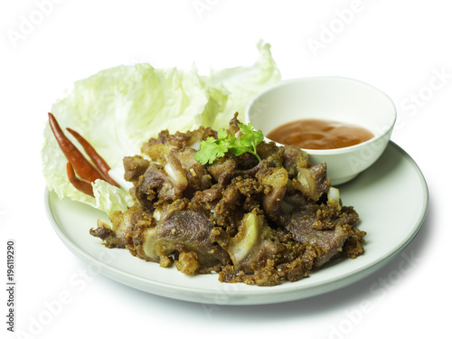 Fried sour pork, fermented pork with sauce, vegetable and chili on dish isolated on white background. sour pork is faverite presevation food in thailand. clipping path included.