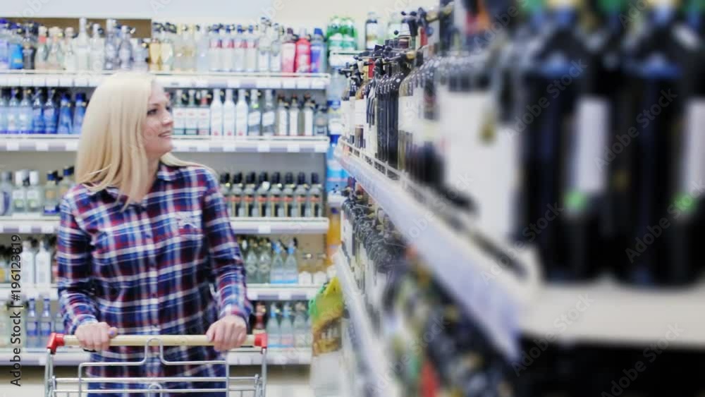 woman chooses wine in a supermarket woman chooses wine in a supermarket