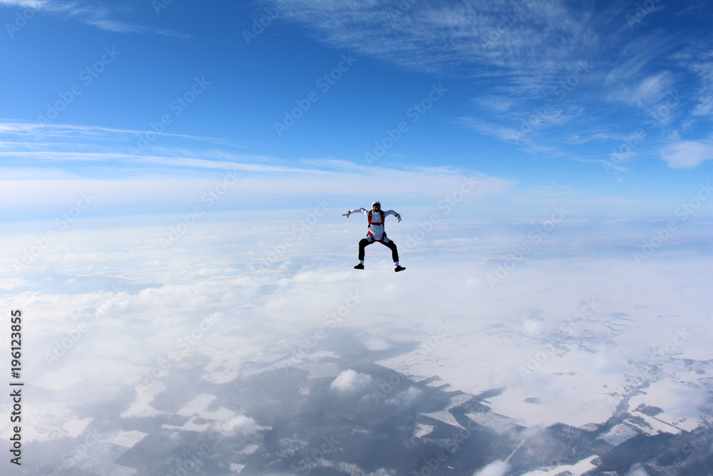 Skydiver is flying in the winter sky.