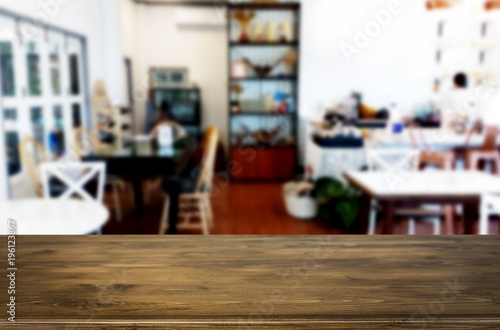 Selected focus empty brown wooden table and Coffee shop or restaurant blur background with bokeh image. for your photomontage or product display.