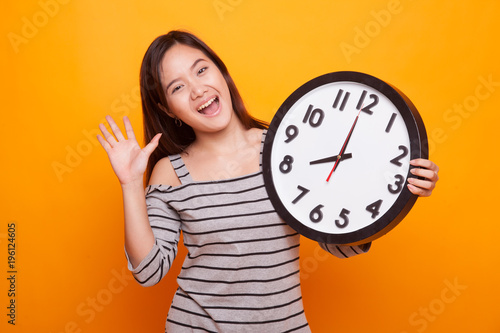 Happy Young Asian woman with a clock.