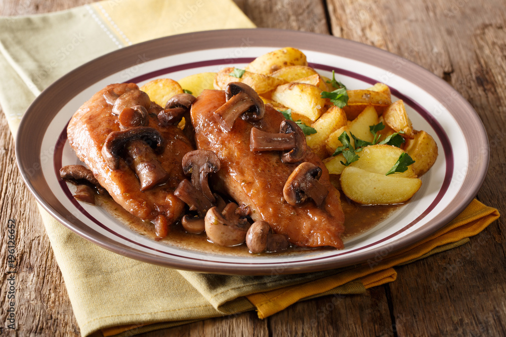 Italian American food: Chicken in Marsala wine with fried mushrooms and potatoes close-up. horizontal Italian American food: Chicken in Marsala wine with fried mushrooms and potatoes close-up. horizontal