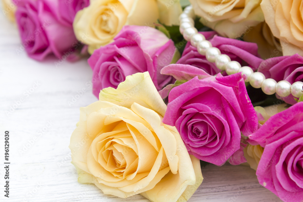 Beautiful roses on a white wooden background. Roses and pearls on a wooden background Beautiful roses on a white wooden background. Roses and pearls on a wooden background