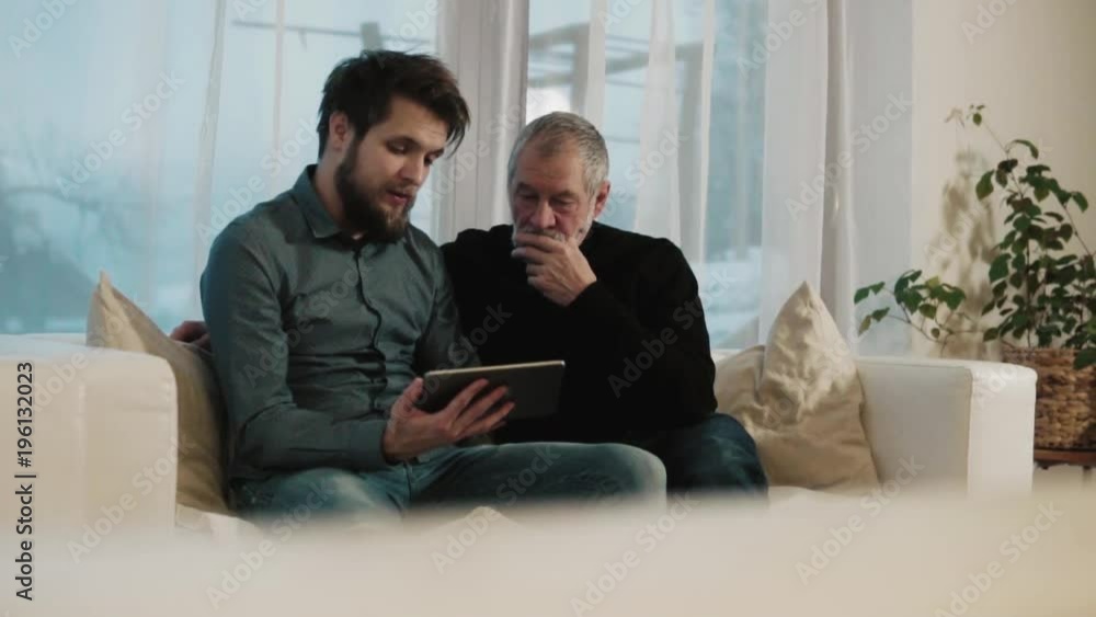 Hipster son and his senior father with tablet at home. Hipster son and his senior father with tablet at home.