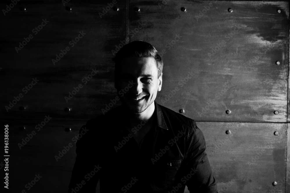 Studio portrait of stylish man wear on black shirt against steel wall. Studio portrait of stylish man wear on black shirt against steel wall.