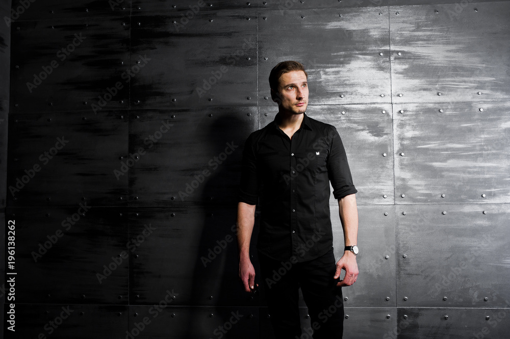 Fototapeta premium Studio portrait of stylish man wear on black shirt against steel wall.