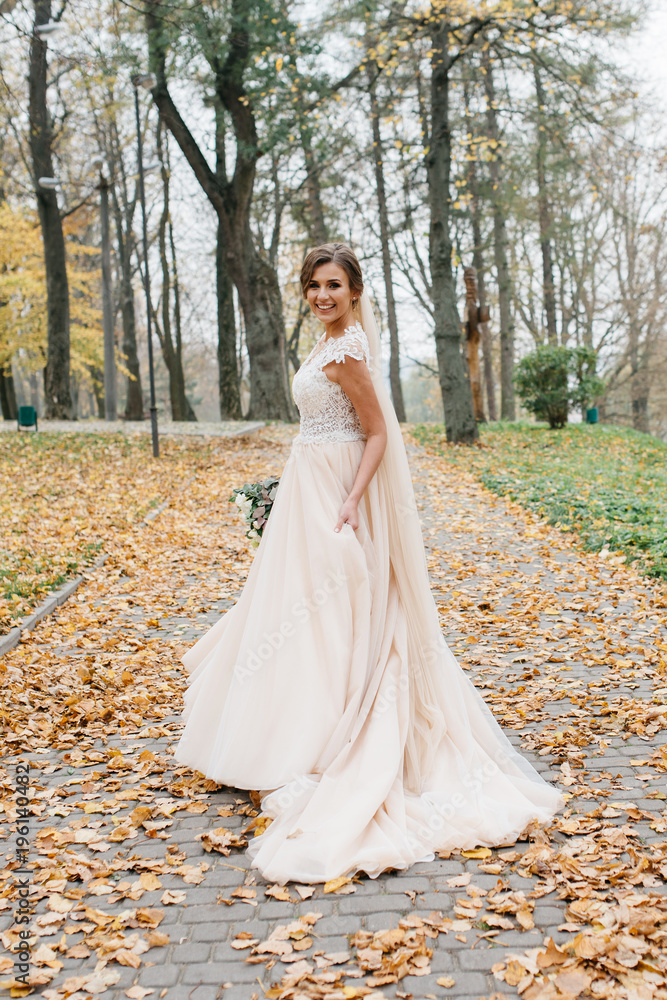Beautiful bride with a wedding bouquet in their hands outdoors in a park