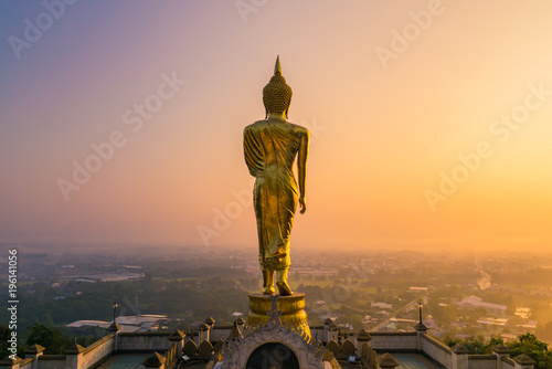 Golden Buddha Statue Beyond Nan City in the Morning, Thailand photo
