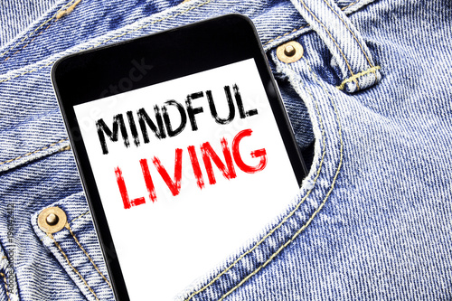 Handwriting Announcement text showing Mindful Living. Business concept for Life Happy Awareness Written phone mobile phone, cellphone placed in the man front jeans pocket. photo