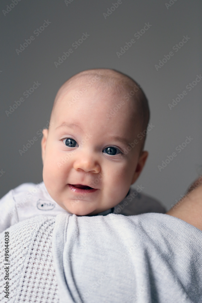 Cute little baby boy with blue eyes looking back from his mothers shoulder. Cute little baby boy with blue eyes looking back from his mothers shoulder.
