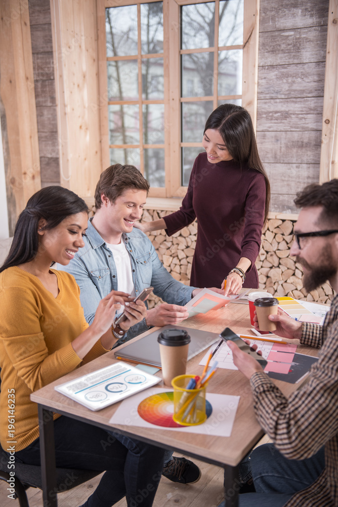 Our project. Joyful nice positive people sitting at the table and focusing on their tasks while working together Our project. Joyful nice positive people sitting at the table and focusing on their tasks while working together