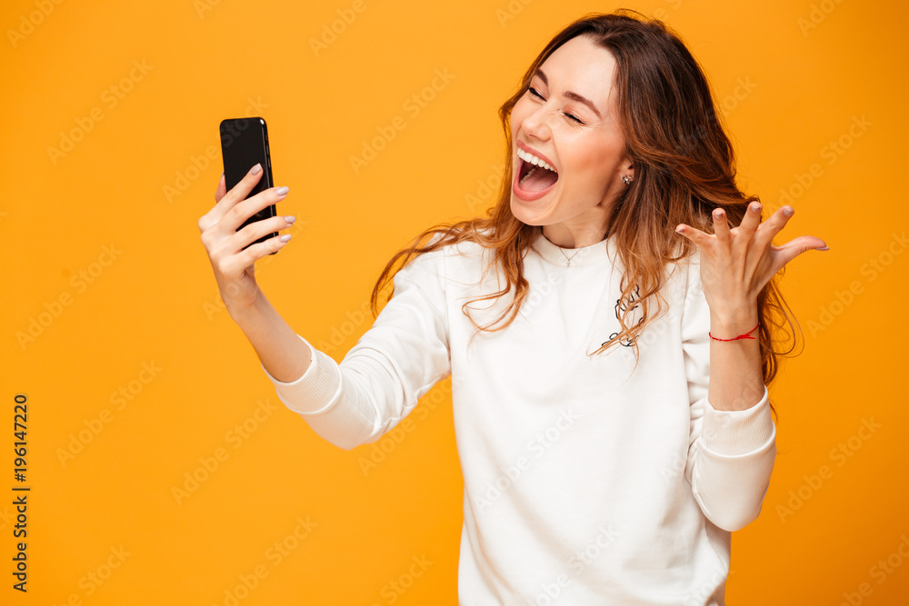 Cheerful brunette woman in sweater laughing with closed eyes Cheerful brunette woman in sweater laughing with closed eyes