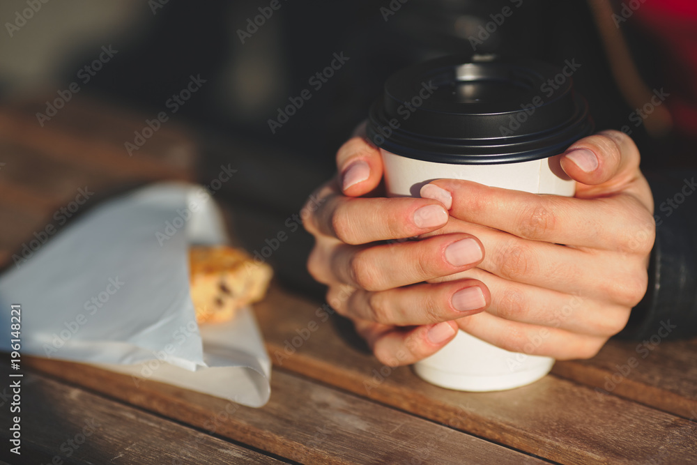 Close up of a hand of woman holding a coffee cup
