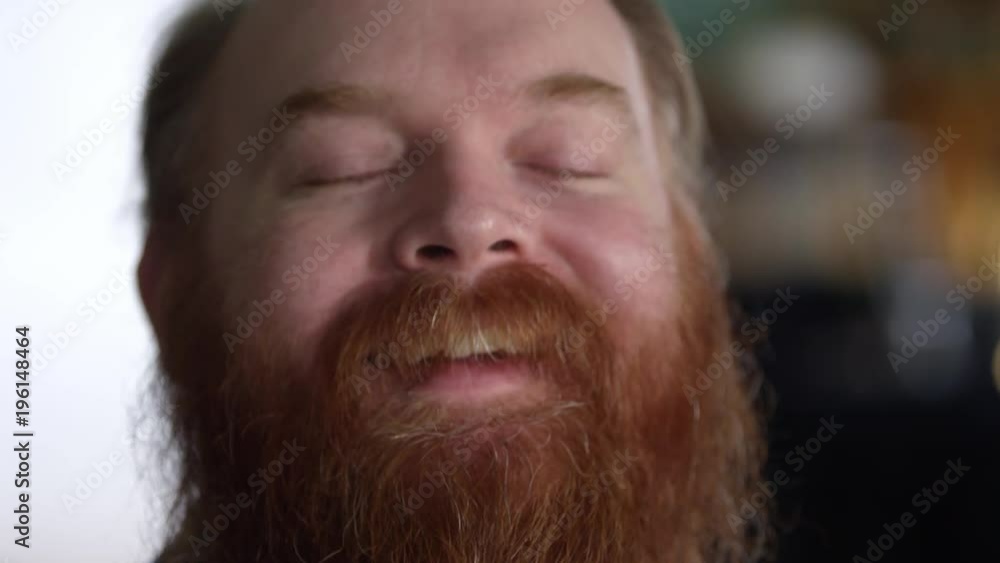 Man with thick red beard laughing from up close view tilting his head back. Man with thick red beard laughing from up close view tilting his head back.
