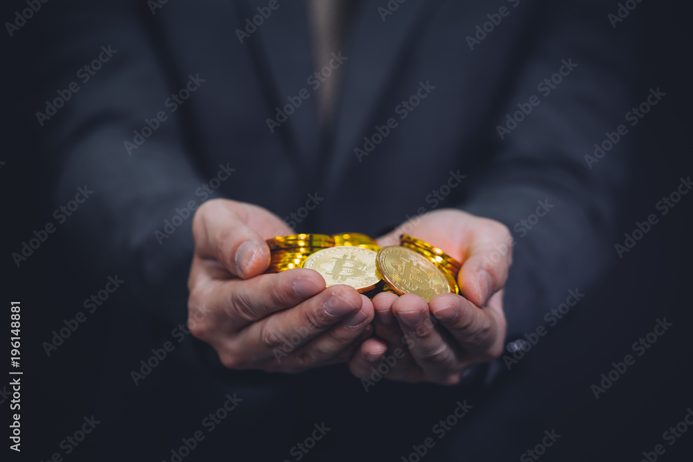 Fototapeta premium Close-up of businessman's hands full of bitcoin sign of coins - cryptocurrency financial trade wealth and business investment and blockchain technology