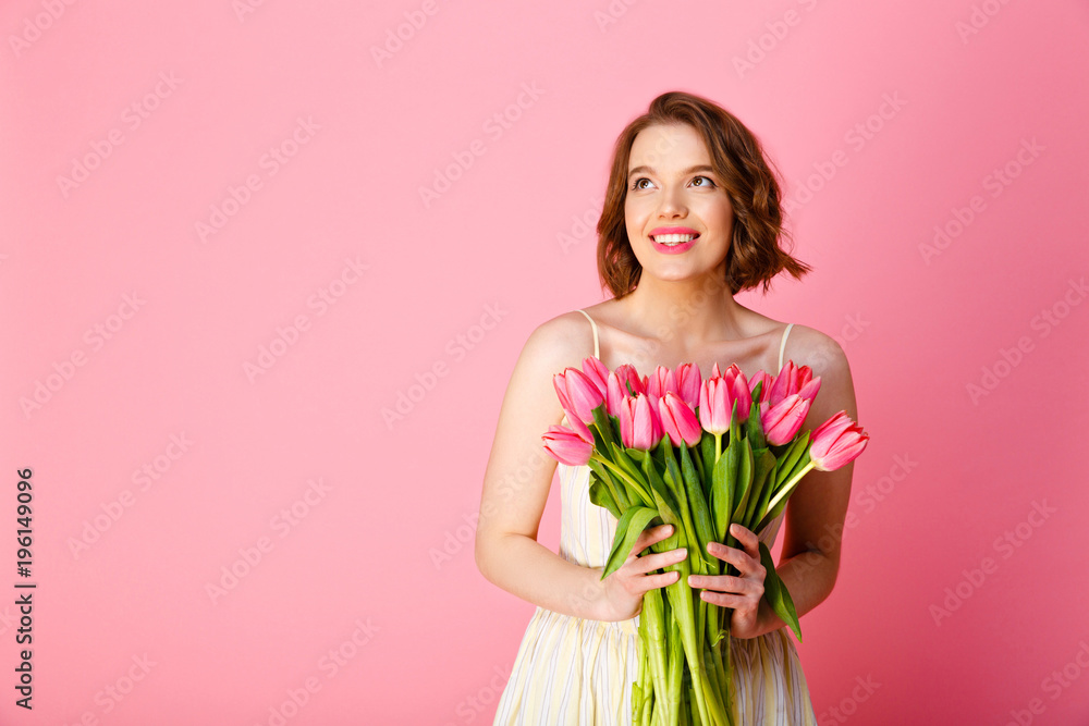 smiling woman with bouquet of pink tulips in hands looking away isolated on pink smiling woman with bouquet of pink tulips in hands looking away isolated on pink