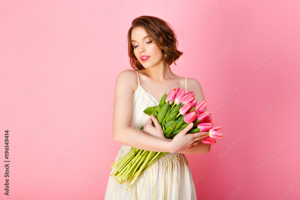 portrait of beautiful woman holding bouquet of pink tulips isolated on pink portrait of beautiful woman holding bouquet of pink tulips isolated on pink