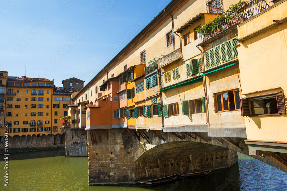 Side view of medieval stone bridge Ponte Vecchio over the Arno River in Florence,