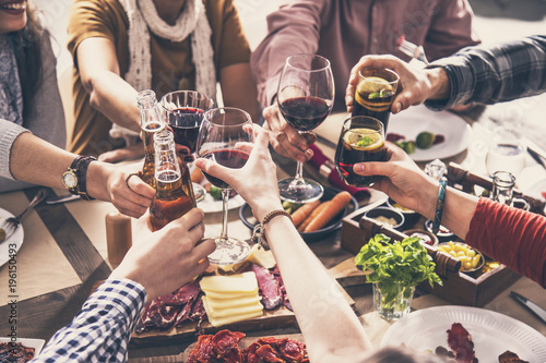 Foto Group of people having meal togetherness dining toasting glasses