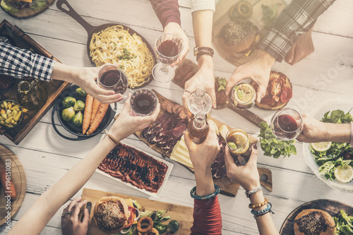 Group of people having meal togetherness dining toasting glasses photo