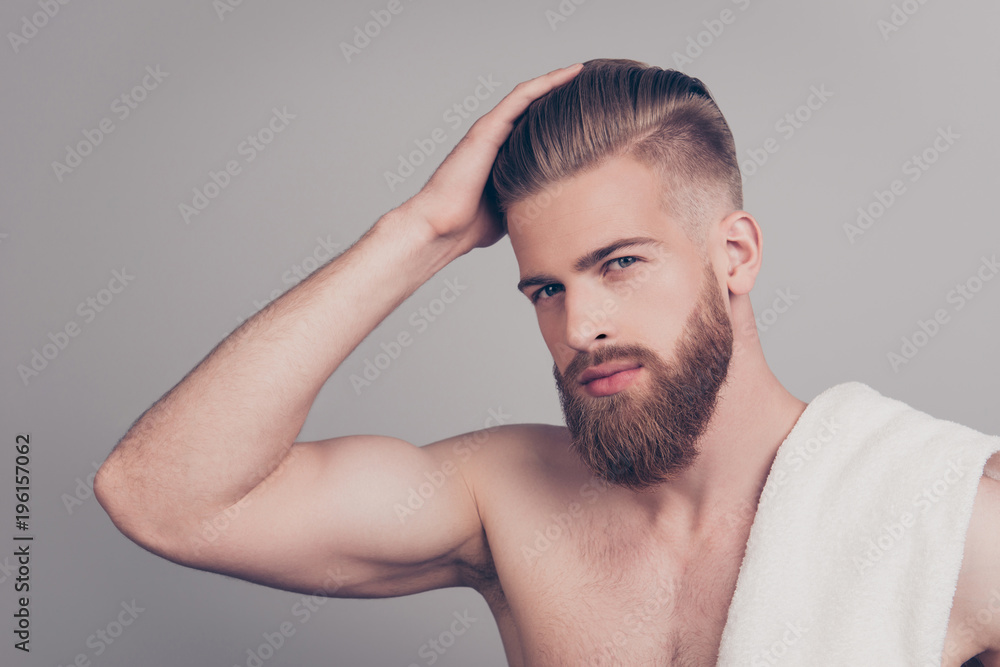 Obraz premium Profile side half-turned portrait of confident sporty virile masculine handsome self-assured stylish trendy modern brutal macho correcting fixing his haircut isolated on gray background