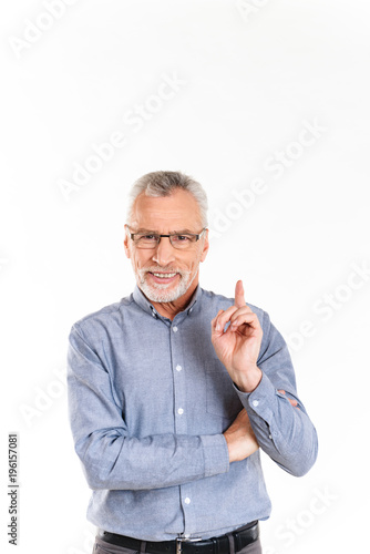 Portrait of old cheerful man pointing up with finger isolated over white photo