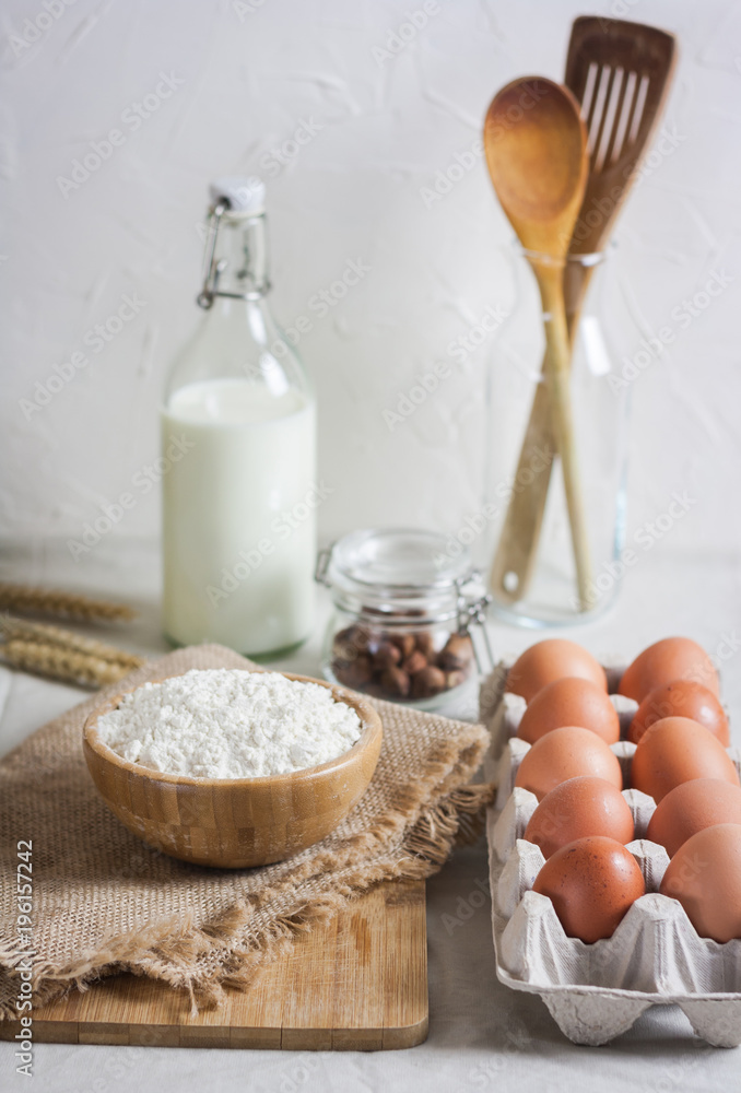 Baking ingredients: flour, eggs, nuts, spiceson white table. Baking ingredients: flour, eggs, nuts, spiceson white table.