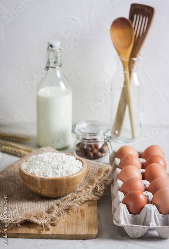 Baking ingredients: flour, eggs, nuts, spiceson white  table.
