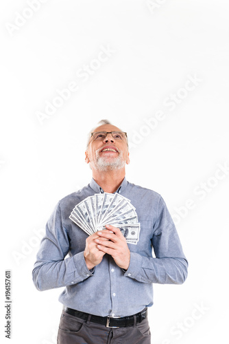 Happy man holding dollars and looking up isolated photo