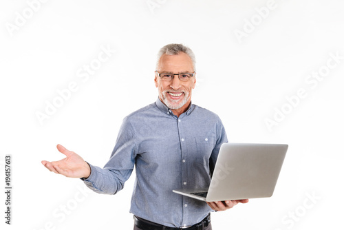 Happy man holding laptop computer and smiling to camera isolated