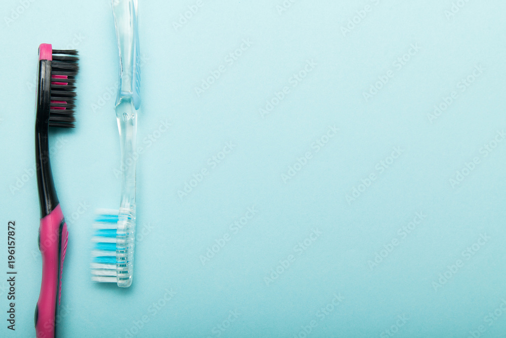 Two new toothbrushes on a blue background, empty space for text. Two new toothbrushes on a blue background, empty space for text.