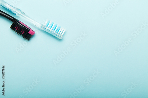 Colorful toothbrushes isolated on blue background. Empty copy space for text.