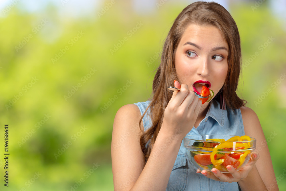 Smiling woman holding glass bowl with salad. Smiling woman holding glass bowl with salad.
