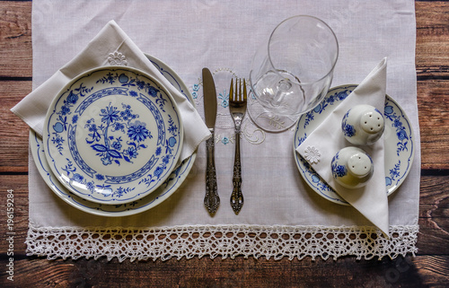 Photography Vintage table setting with china and silver cutlery on the wooden background