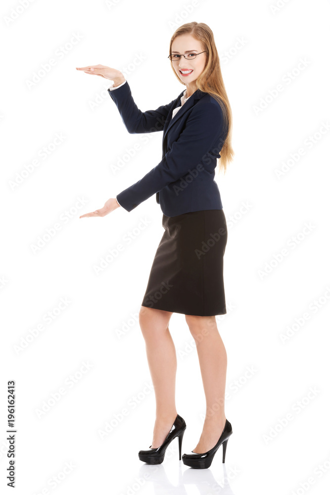 Beautiful caucasian business woman is having empty space between her hands. Beautiful caucasian business woman is having empty space between her hands.