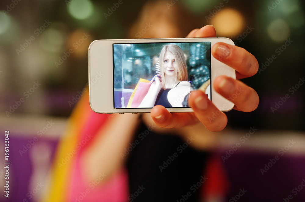 Girl with shopping bags on screen at phone.