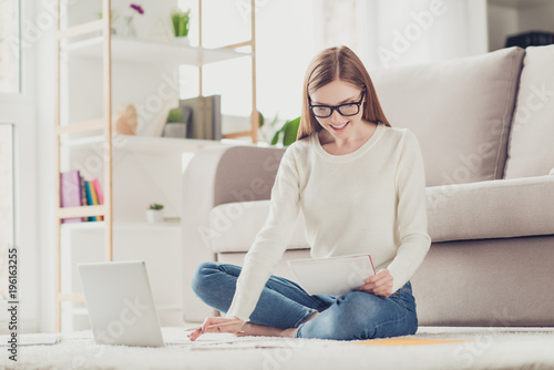 Information crossed legs network help university success story netbook learning people concept. Lovely clever smart girl sitting on white fluffy carpet preparing report for job wearing denim jeans © deagreez