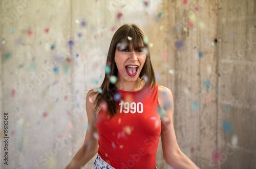 Beautiful young girl playing with confetti