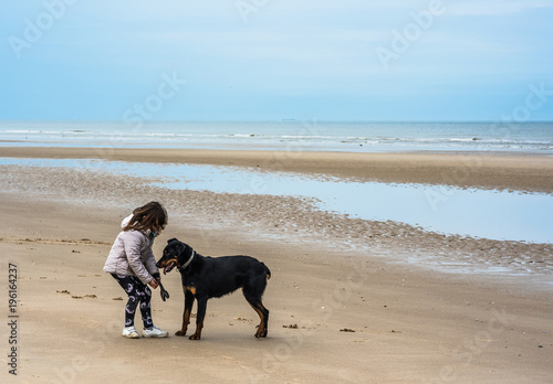 jeune fille et son chien jouant au frisbee