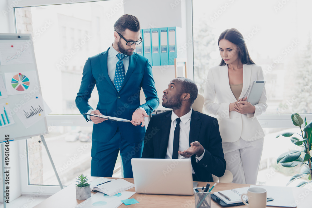 Obraz premium Three thoughtful, stylish, attractive, confident, elegant directors working in work place, station, holding clipchart, gesturing with hand, explaining, having debate, dispute, finding solution