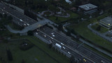 Aerial night view of an overhead road and bridge crossing an Italian highway. On the road, many cars drive at high speed with the headlights on.