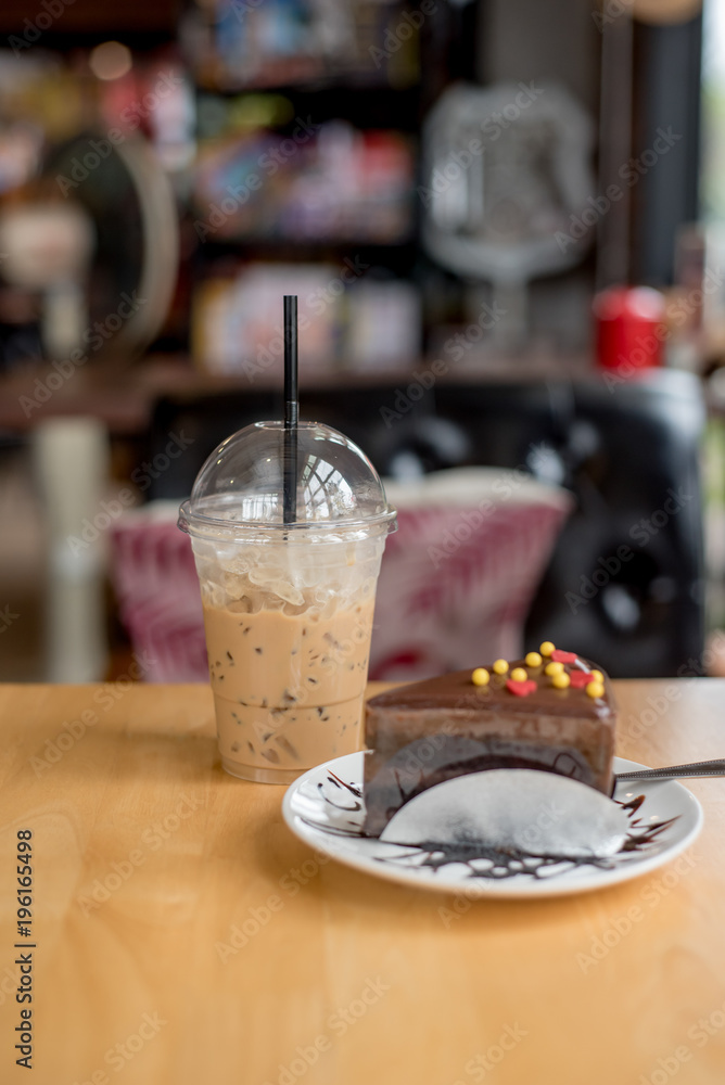 ice coffee take away and cake on wooden background