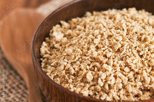 Closeup of dried raw soya mince in wooden bowl