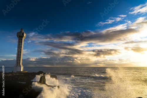 The Lighthouse "Faro de Punta Lava" in La Bombilla near Puerto Naos at La Palma / Canary Islands at stormy weather and sunset