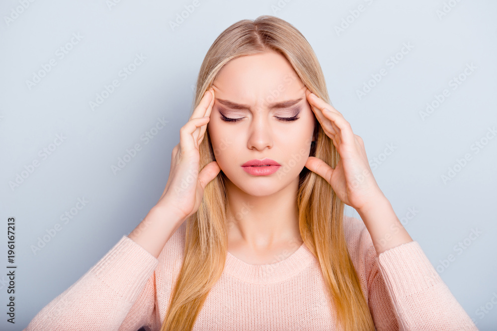 Education sick unwell university lifestyle spasm people person concept. Close up portrait of sad upset unhappy exhausted frustrated troubled woman touching temples isolated on gray background Education sick unwell university lifestyle spasm people person concept. Close up portrait of sad upset unhappy exhausted frustrated troubled woman touching temples isolated on gray background