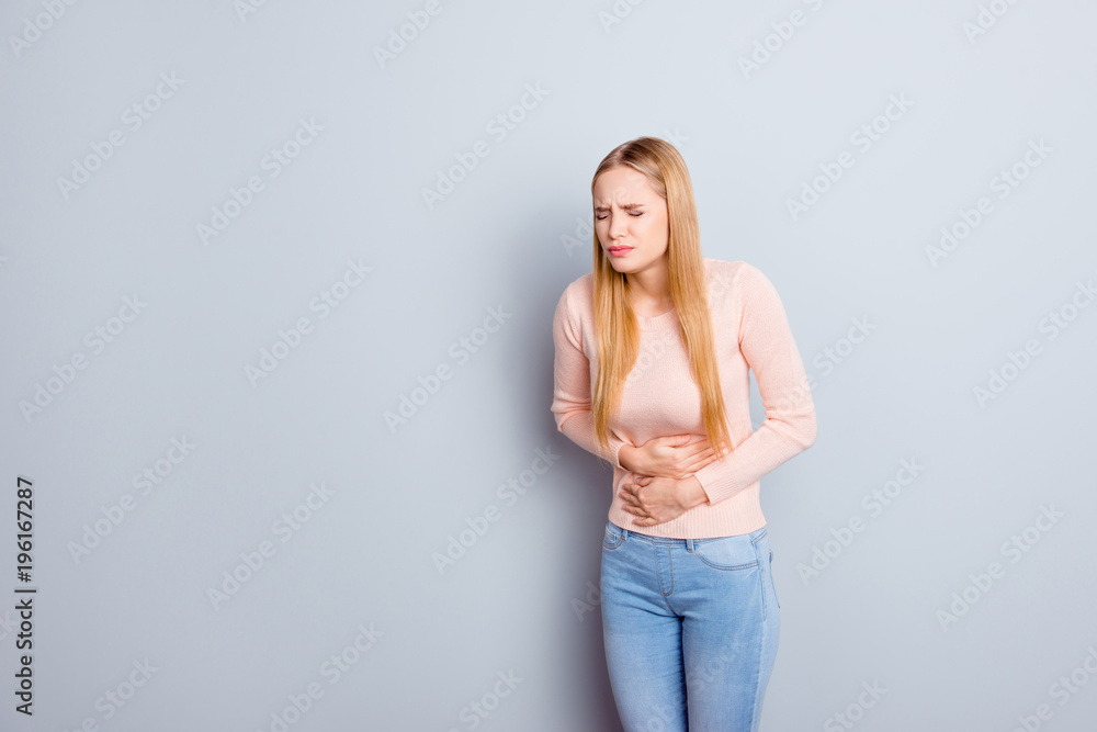 Portrait of sad unhappy upset stressed frustrated depressed crying troubled nervous bad negative feeling woman touching holding tummy with hands isolated on gray background copy-space Portrait of sad unhappy upset stressed frustrated depressed crying troubled nervous bad negative feeling woman touching holding tummy with hands isolated on gray background copy-space
